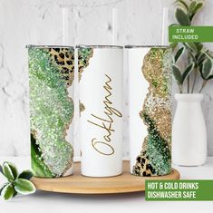 three white tumbles with gold glitter and green leaves