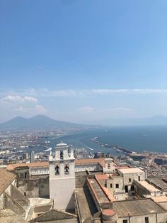 an aerial view of the city and ocean from atop a building with two bell towers