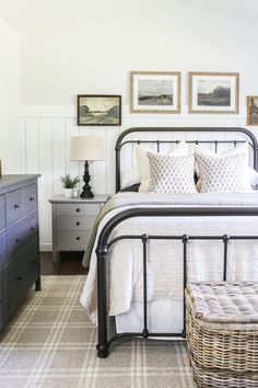 a bed room with a neatly made bed and dressers