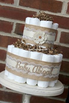 a three tiered diaper cake with burlocks and lace