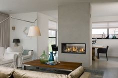 a living room filled with furniture and a fire place next to a wall mounted fireplace