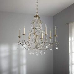 a chandelier hanging from the ceiling in a room with white walls and windows