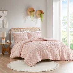 a bed with pink comforters and pillows in a room