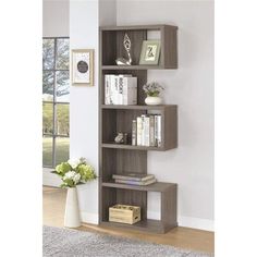 a book shelf with several books on top of it next to a vase filled with flowers