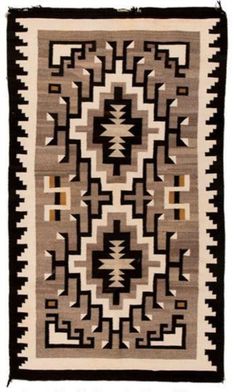 an old navajo rug with black and white designs on the front, brown and tan colors