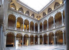 the inside of a large building with columns and arches on it's ceiling,