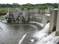 water gushing out from the top of a dam with two gates on each side