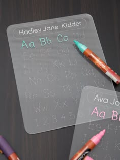 three markers are sitting on top of a plastic placemat that says aa, b, and c