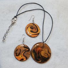 2" Wooden Round Pendant Is Hand Painted In A Fluid Art Technique With Metallic Copper, Brown, Black And Metallic Gold. Matching Earrings Are 1 1/2" Wooden Round Disks. These Colors Shimmer With Richness Which Is Enhanced By The High Gloss Resin Finish. Very Lightweight Earrings So They Won't Weigh Down Your Ear Lobes. French Ear Wires Are Sterling Silver Stamped .925 So No Worries There. Pendant Hangs From A Satin Cord And Necklace Measures 16" Plus A 2 1/2" Chain Extension. Unique Set Is One Of Wood Resin Necklace, Copper Brown, Painted Earrings, Metallic Copper, Wooden Pendant, Wood Resin, Resin Necklace, Lightweight Earrings, Handcrafted Wood