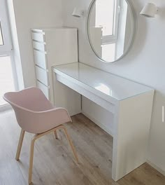 there is a white desk and chair in this room with a round mirror on the wall