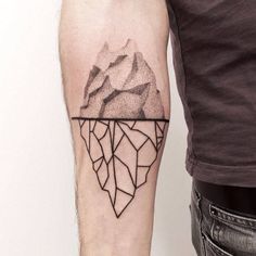 a man with a tattoo on his arm that has a mountain in the middle and lines coming out of it