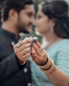 a man and woman holding hands while standing next to each other with rings on their fingers