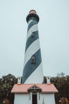 a white and black lighthouse with a red roof