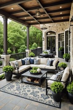 an outdoor living area with couches, tables and potted plants on the patio