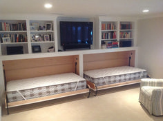 there are two beds in this room with built - in bookshelves on the wall