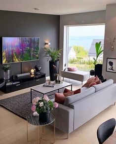 a person laying on a couch in front of a large window looking out onto the ocean