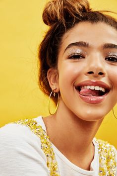 a young woman smiling and wearing large hoop earrings