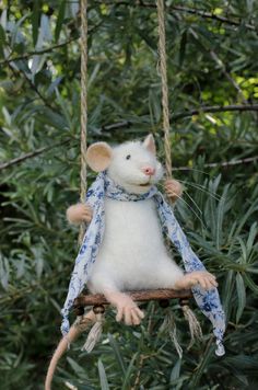 a stuffed mouse hanging from a tree branch