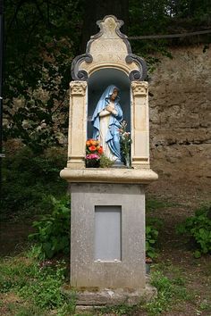 a statue of the virgin mary holding flowers