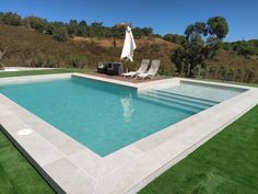 an empty swimming pool surrounded by grass