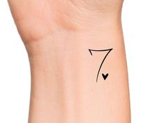 a woman's wrist with the number seven drawn on her left arm and an arrow in the middle