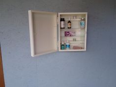 an open medicine cabinet on the wall