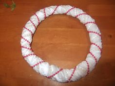 a white and red rope bracelet sitting on top of a wooden table