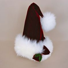 a red and white santa hat with pom - poms hanging from it's side