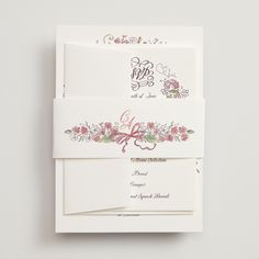 the wedding stationery is laid out on top of each other, with floral designs