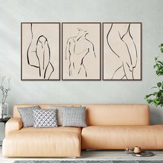 three framed nude female torsos on the wall above a couch in a living room