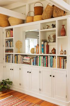 a bookshelf filled with lots of books and baskets