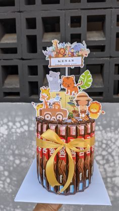 a cake made out of candy bars with stickers on it and a ribbon around the top