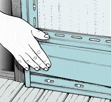 a hand reaching for something in an open drawer on the floor next to a door