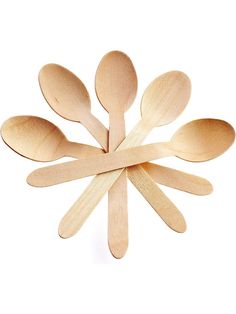 wooden spoons arranged in the shape of a snowflake on a white background