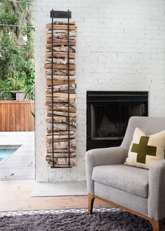 a chair sitting in front of a fire place next to a fireplace with logs on it