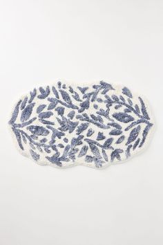 a blue and white plate with leaves on it, against a white background that looks like something out of space