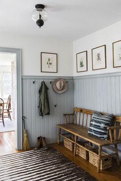 a wooden bench sitting in the middle of a living room next to a rug on top of a hard wood floor