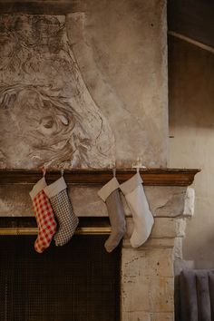 three stockings hanging from a fireplace mantel