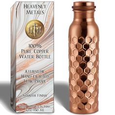 a copper colored bottle next to a cardboard box for it's contents and packaging