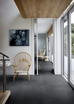 a chair sitting in the middle of a hallway next to a painting on the wall