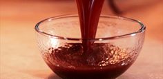 a red liquid being poured into a glass bowl