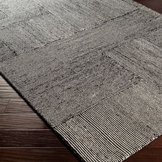 a black and white rug on top of a wooden floor