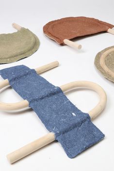 several pieces of cloth and wooden handles on a white surface