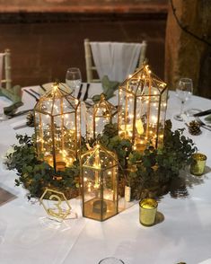 a table topped with lots of lights and greenery