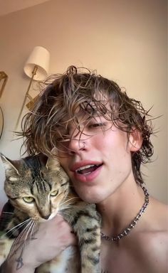 a woman holding a cat in her arms and looking at the camera while she's smiling