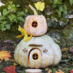 a pumpkin shaped house sitting on top of a rock