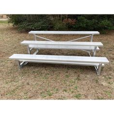 two benches sitting on top of a grass covered field