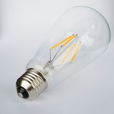 a light bulb with some yellow sticks sticking out of it's side on a white background