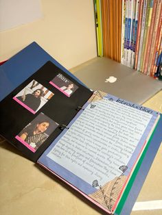 an open book sitting on top of a table next to a laptop computer and bookshelf