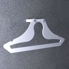 a white plastic hanger sitting on top of a gray floor